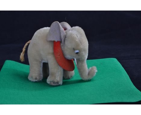 Vintage Steiff mohair elephant with tusks, felt ears and red felt saddle cloth, Steiff button to ear, height 10cmAge related 