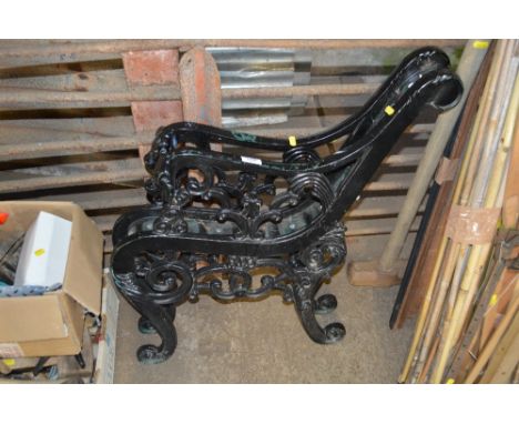 A pair of black painted bench ends 