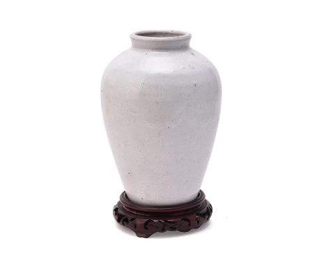 A white glazed stoneware vase, possibly Qing Dynasty, with thick white crackled glaze and blue fleck inclusions, the base wit