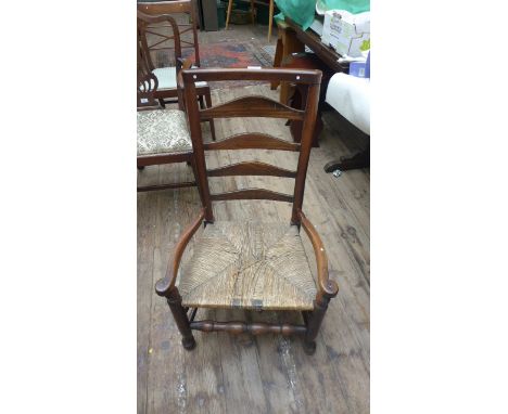 Ladder backed low seated armchair with ropework seat in similar style