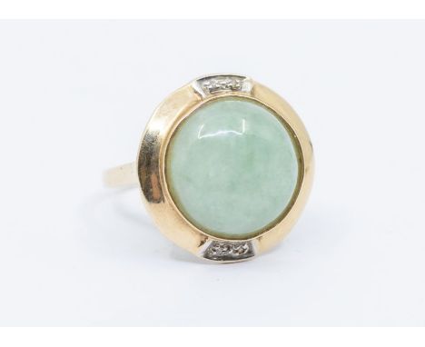 A jadeite and diamond 9ct gold dress ring, comprising a round cabochon stone approx 14mm, within a gold border set to top and