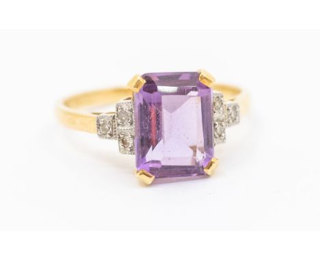 An amethyst and diamond 18ct gold ring, claw set with and emerald cut amethyst with stepped shoulders set with three diamonds