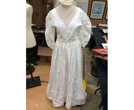 An early 1980's Laura Ashley wedding dress, in taffeta, full length, cross out bodice, short puff sleeves with button, wide s