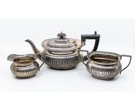 A Georgian style three piece silver tea service, comprising teapot, sugar bowl and milk jug, gadroon bodies, the teapot with 