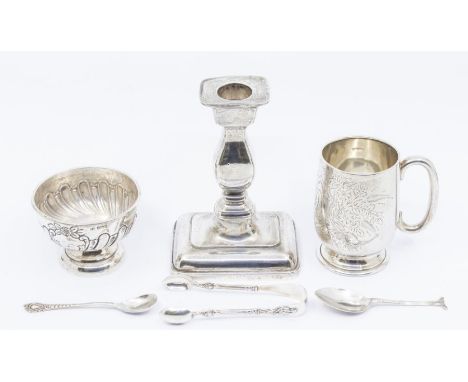 A collection of hallmarked silver including a christening mug, a weighted candlestick, a sugar basin, 2 spoons and a pair of 