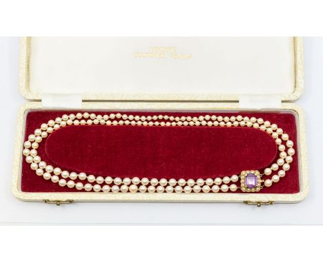 A double row graduated cultured pearl necklace with 9ct and amethyst clasp, length approx 46cm, strung knotted,  total gross 