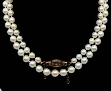 A cultured pearl single row long necklace, each pearl approx  8.2mm, strung knotted to a decorative enamel and unmarked yello