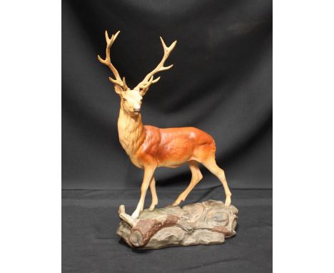 A Beswick ceramic model of a stag, on a naturalistic woodland base.