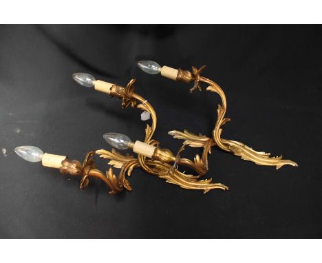 A pair of gilt brass two-light wall sconces of scrolling foliate form