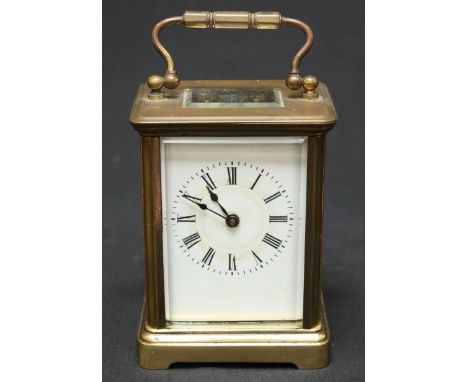 A brass carriage clock with white enamel dial and brass carrying handle. 14 cm high.