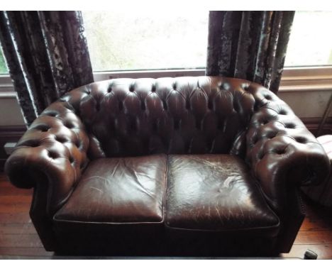 A brown leather button back Chesterfield two seater sofa, approx 