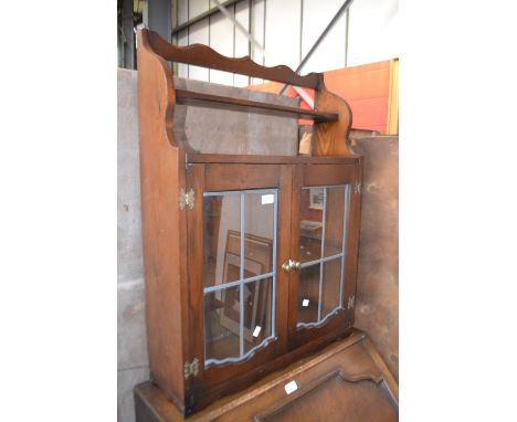 A stained pine wall cabinet, two leaded glass doors over single shelf.