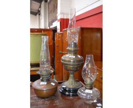 An ovoid pedestal oil lamp, circular socle;  a clear glass oil lamp;  another (3) 