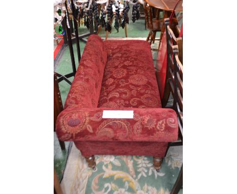 A Victorian scroll arm chaise, button back, stuffed seat, turned supports, brass castors