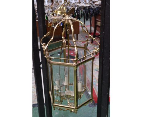 A contemporary ceiling light, brass and glass hexagonal shade with six branch light fitting.