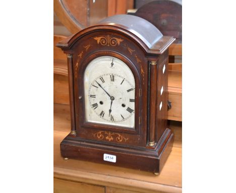 An Edwardian dome top bracket clock, arched silvered face, Roman numerals, flanked by columns, decorated with satinwood inlai