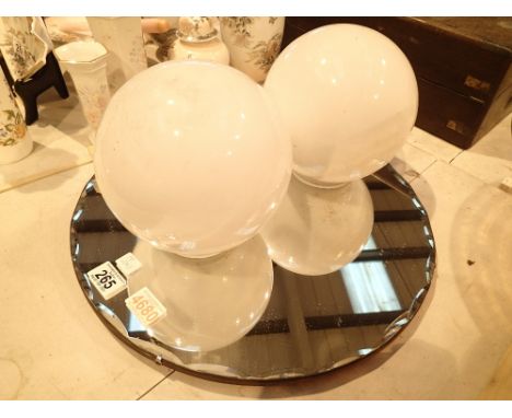 Two white globular glass light shades and a circular wall mirror 