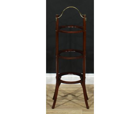 An Art Nouveau mahogany and brass three-tier patisserie waiter, lofty carry handle in the Secessionist manner, above three ci