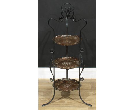 An Art and Crafts copper and wrought iron three tier afternoon tea stand, each plateau repousse chased, 92cm high, c.1910 