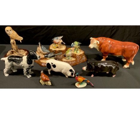 A Beswick model of a spaniel, a pig, assorted garden bird models on a stand, a pheasant, a Royal Doulton model of a pig; a St