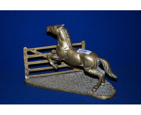 A brass model of a horse about to leap a field gate