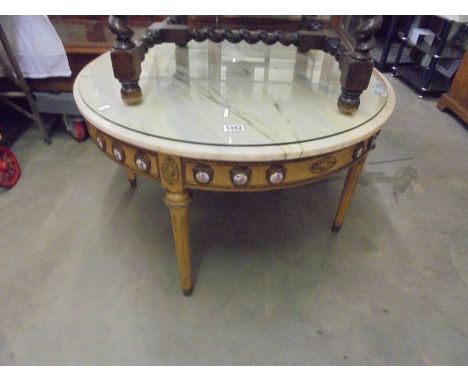 A circular Italian style marble top coffee table with protective glass top.