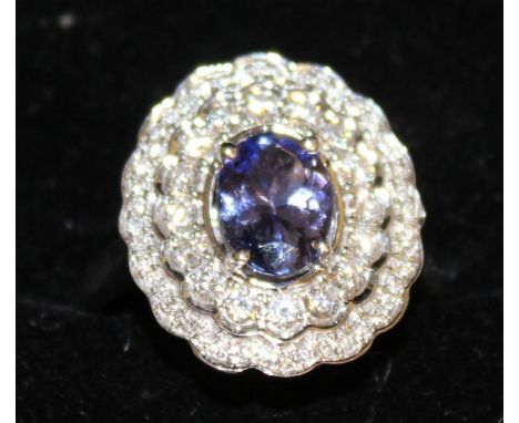 A GOOD LARGE TANZANITE AND DIAMOND OVAL CLUSTER RING, set in 18ct white gold.