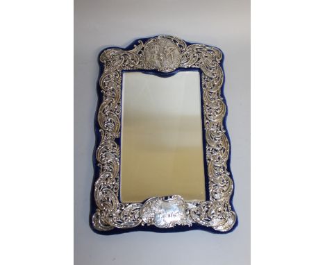 A GOOD VICTORIAN UPRIGHT EASEL MIRROR with scrolls and repousse decoration, on a blue velvet background. 17ins high.  Birming