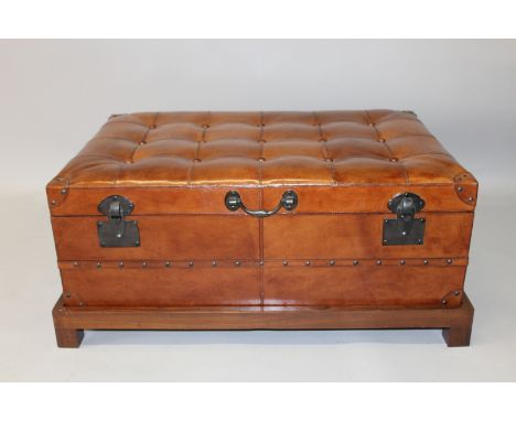A GOOD LEATHER BUTTON UPHOLSTERED TRUNK on a wooden stand. 3ft 0ins wide.