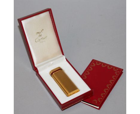 A CARTIER GOLD PLATED GAS LIGHTER, in original red box with paperwork.