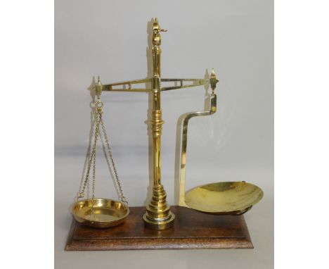 A GOOD LARGE SET OF BRASS SCALES AND WEIGHTS on a wooden base. 19ins high.