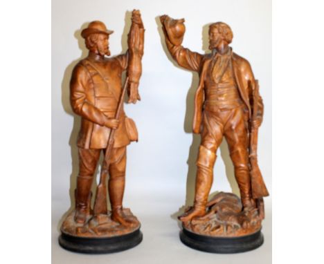 A PAIR OF 19TH CENTURY AUSTRIAN TERRACOTTA HUNTING FIGURES of men carrying guns and game, supported on circular bases. 20ins 