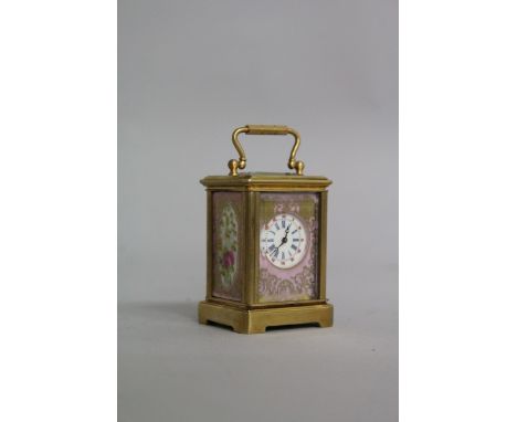 A MINIATURE BRASS AND SEVRES CARRIAGE CLOCK with painted porcelain panels.  2ins high.
