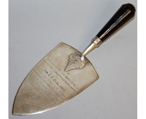 AN EBONY HANDLED PRESENTATION SILVER TROWEL, engraved "PRESENTED BY THE DIRECTORS OF BOVIS FEE CONSTRUCTION LTD. ............