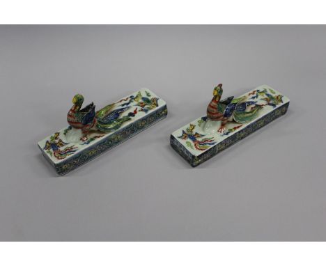 A PAIR OF CHINESE DOUCAI PORCELAIN SCROLL WEIGHTS, each of rectangular form and moulded with a phoenix in high relief, each w