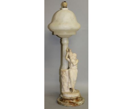 A GOOD 1920'S ALABASTER LAMP formed as a classical female figure carrying a pitcher and standing beside a column. 26ins high.