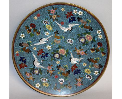 A GOOD 19TH CENTURY JAPANESE CLOISONNE ENAMEL CIRCULAR PLATE, blue ground with flowers and storks. 9.5ins diameter.
