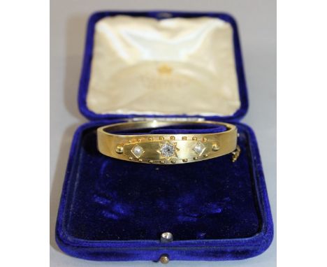 A VICTORIAN YELLOW GOLD BANGLE set with single stone diamond and pair of pearls.