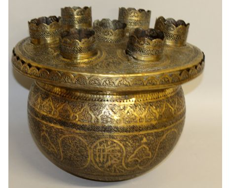 A 19TH CENTURY BRASS MOSQUE LAMP with engraving and calligraphy, hanging chains missing. 12ins diameter.