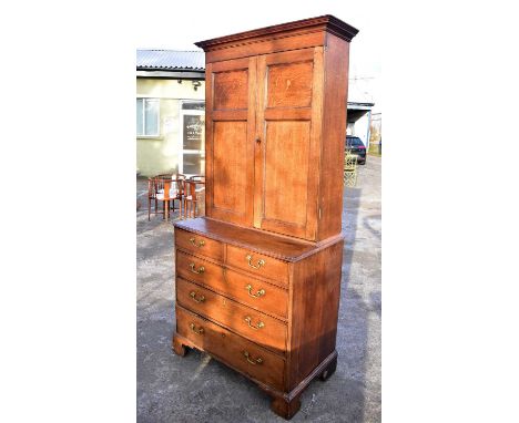 A 19th century oak cabinet, with pair of panel doors on a base of two short and three long drawers with bracket feet, width 9