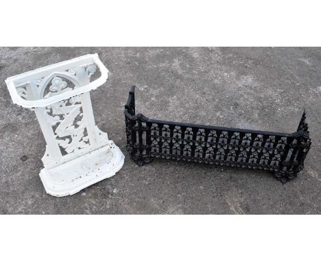 A cast iron fender (af), width 80cm, and a white painted cast iron stick stand, height 50cm.The fender is damaged to the righ