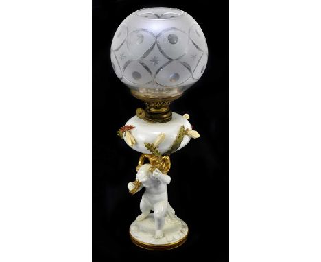 MOORE BROS: a 19th century oil lamp, the circular reservoir with applied floral decoration supported by a cherub, with froste