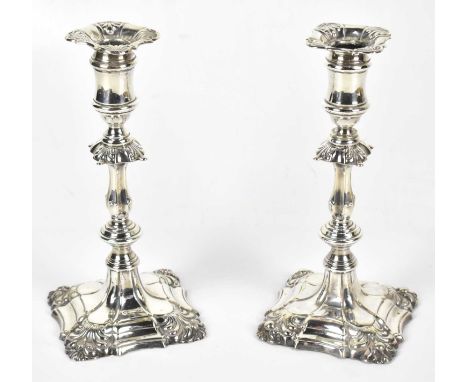 IS GREENBERG &amp; CO; a pair of late Victorian Georgian style candlesticks decorated with cast open shells, Birmingham 1900,