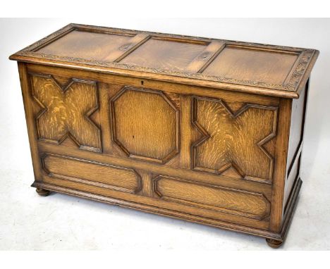 An oak blanket box, the three panel lid above a panelled front, width 120cm