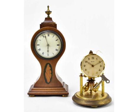 An Edwardian inlaid mahogany time piece with urn finial above the enamel dial set with Arabic and Roman numerals, on four bal