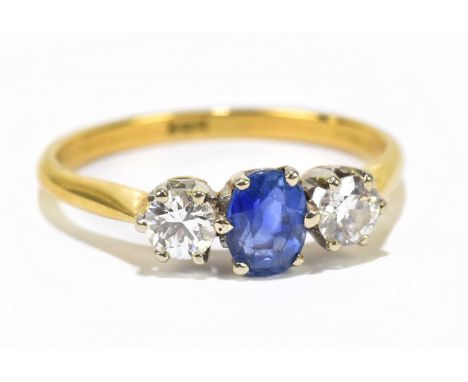 A yellow metal three stone diamond and sapphire dress ring, the central sapphire flanked by a pair of brilliant cut diamonds,
