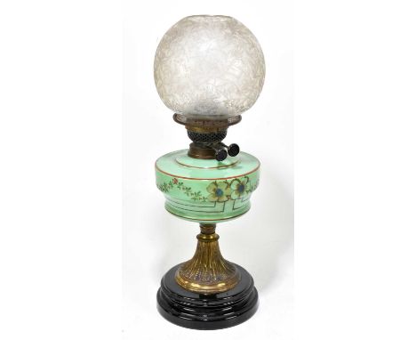 A Victorian oil lamp, the clear frosted glass shade above the opaque glass reservoir with painted floral decoration on a bras