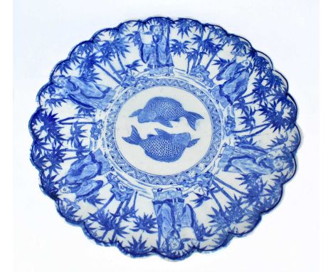 An early 20th century Japanese blue and white charger decorated to the centre with carp flanked by figures in bamboo trees to