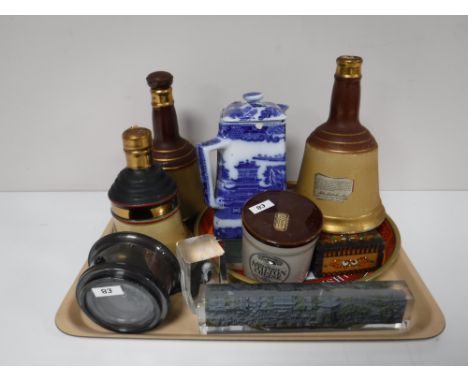 A tray containing Bells scotch whiskey decanters, a cased Royal Navy ships compass, glass paperweights, Ringtons blue and whi