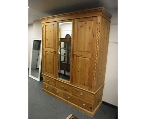 A pine triple door wardrobe fitted five drawers beneath, width 175cm